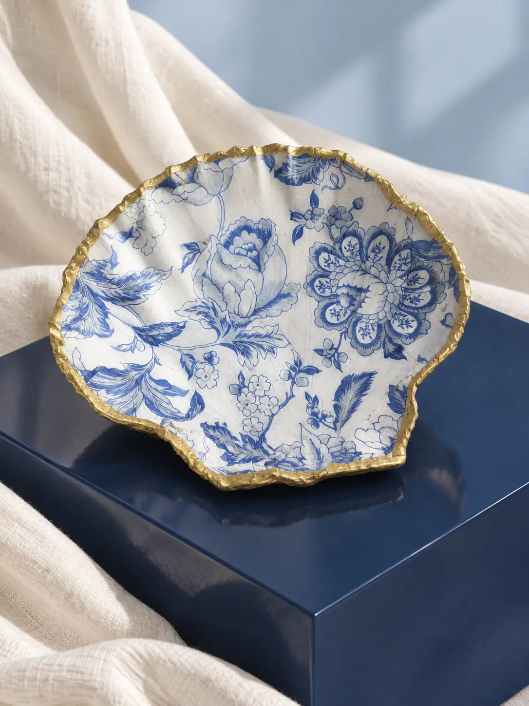 Coquille Saint-Jacques ornée de fleurs bleu porcelaine, bordure dorée, esprit faïence ancienne.