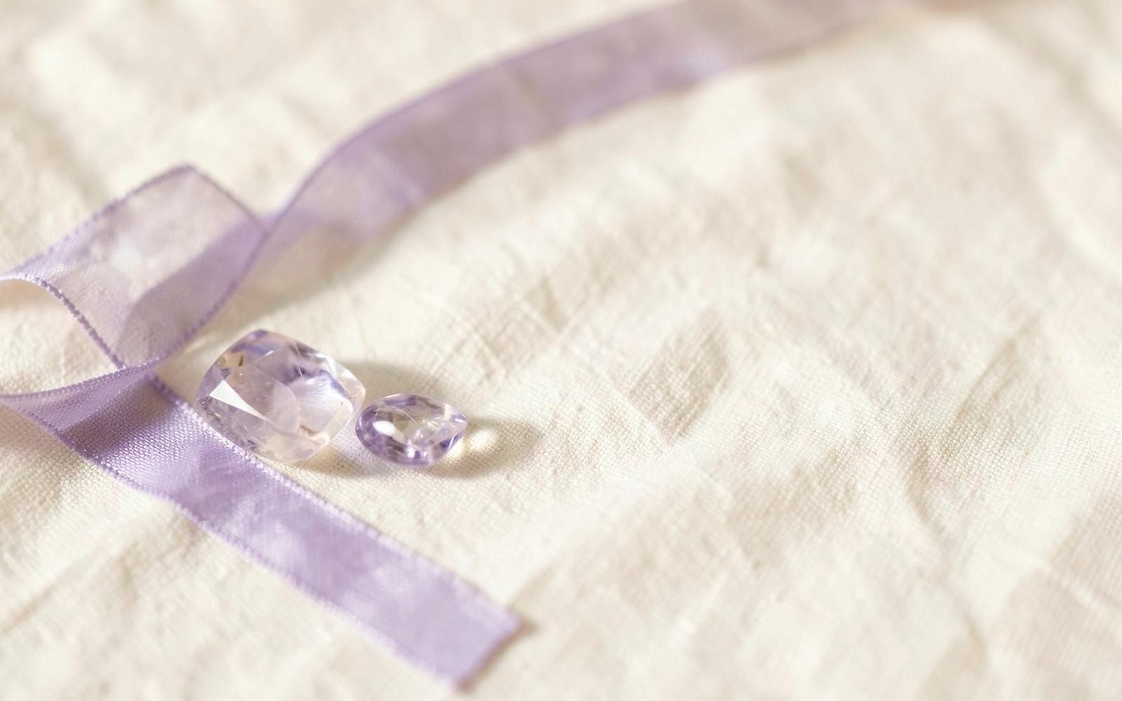 Pierres améthyste et ruban violet sur un lin ivoire